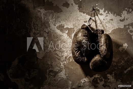 Bild på old boxing gloves hang on nail on texture wall
